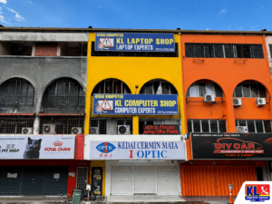 KL Laptop Shop building in Kuala Lumpur featuring a bright yellow storefront with large laptop repair and computer service signage, located among neighboring commercial shop lots.