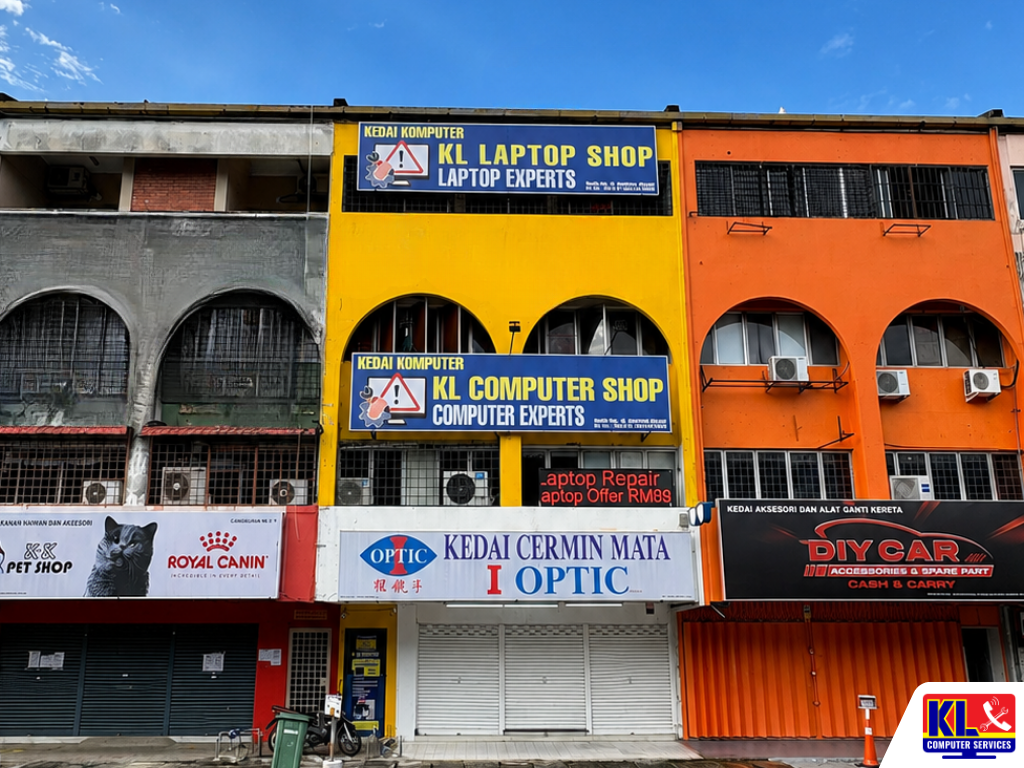KL Laptop Shop building in Kuala Lumpur featuring a bright yellow storefront with large laptop repair and computer service signage, located among neighboring commercial shop lots.