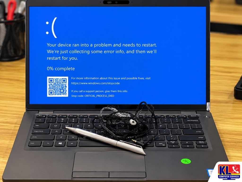 Laptop displaying a Windows blue screen error with the stop code CRITICAL_PROCESS_DIED on a computer repair workbench.