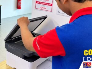 IT technician opening a multifunction printer to inspect the scanner and printer components during troubleshooting.