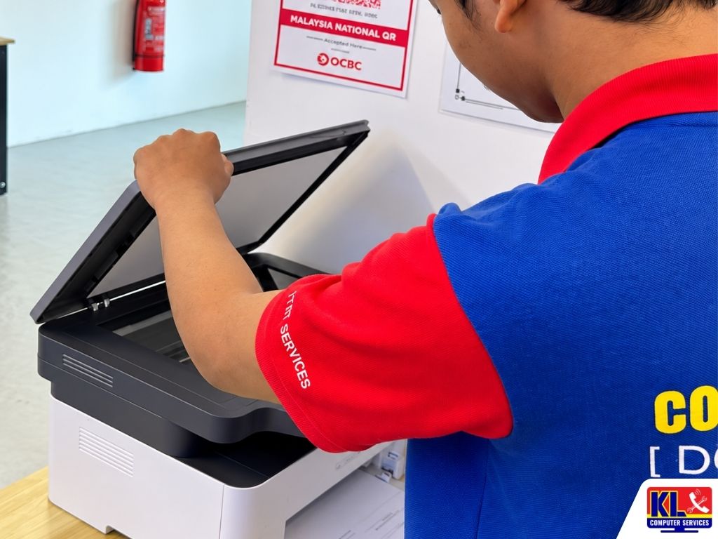 IT technician opening a multifunction printer to inspect the scanner and printer components during troubleshooting.